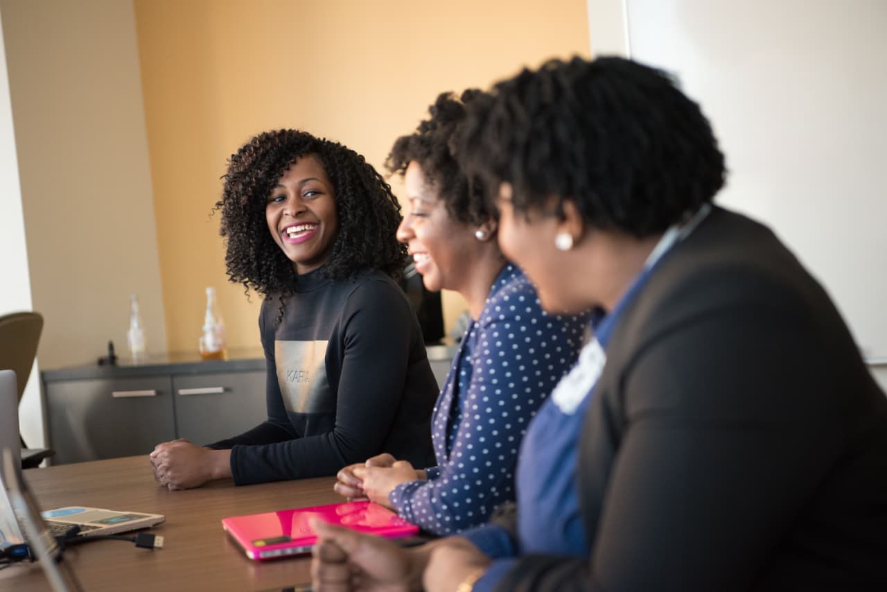 Three colleagues sharing a conversation around a table